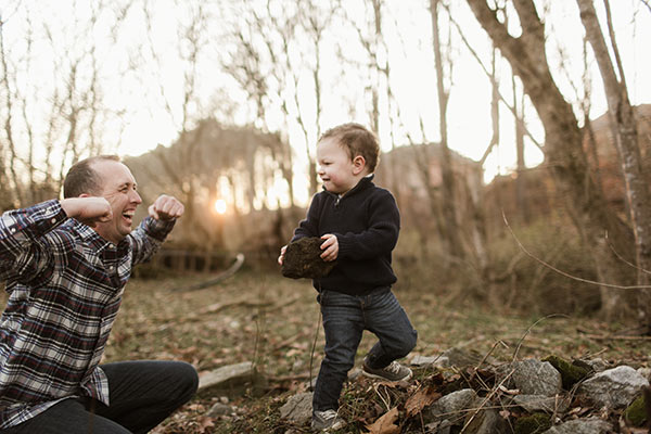 Brooks holding a rock and Ian smiling and flexing his muscles