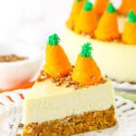 A slice of carrot cake cheesecake on a dessert plate with a small fork