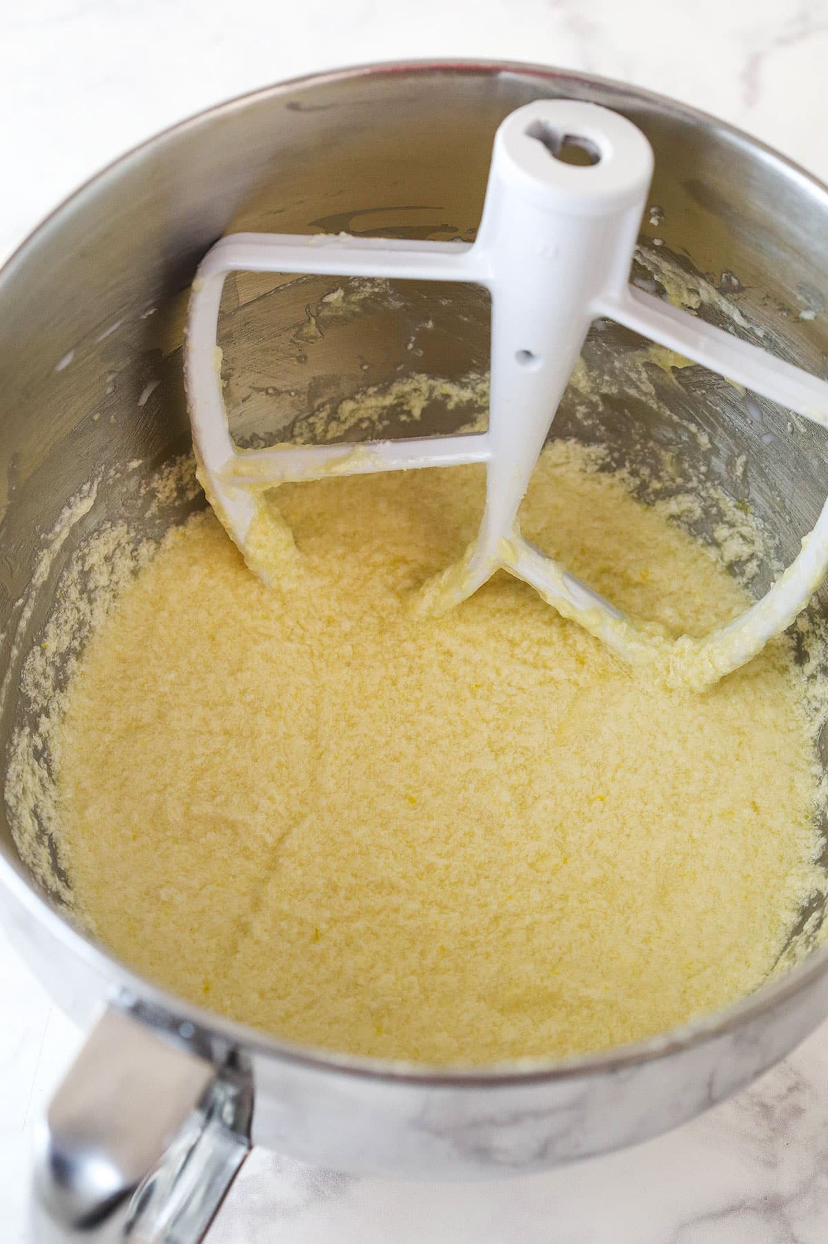 Overhead view of dry ingredients and milk combined to batter in a large mixing bowl