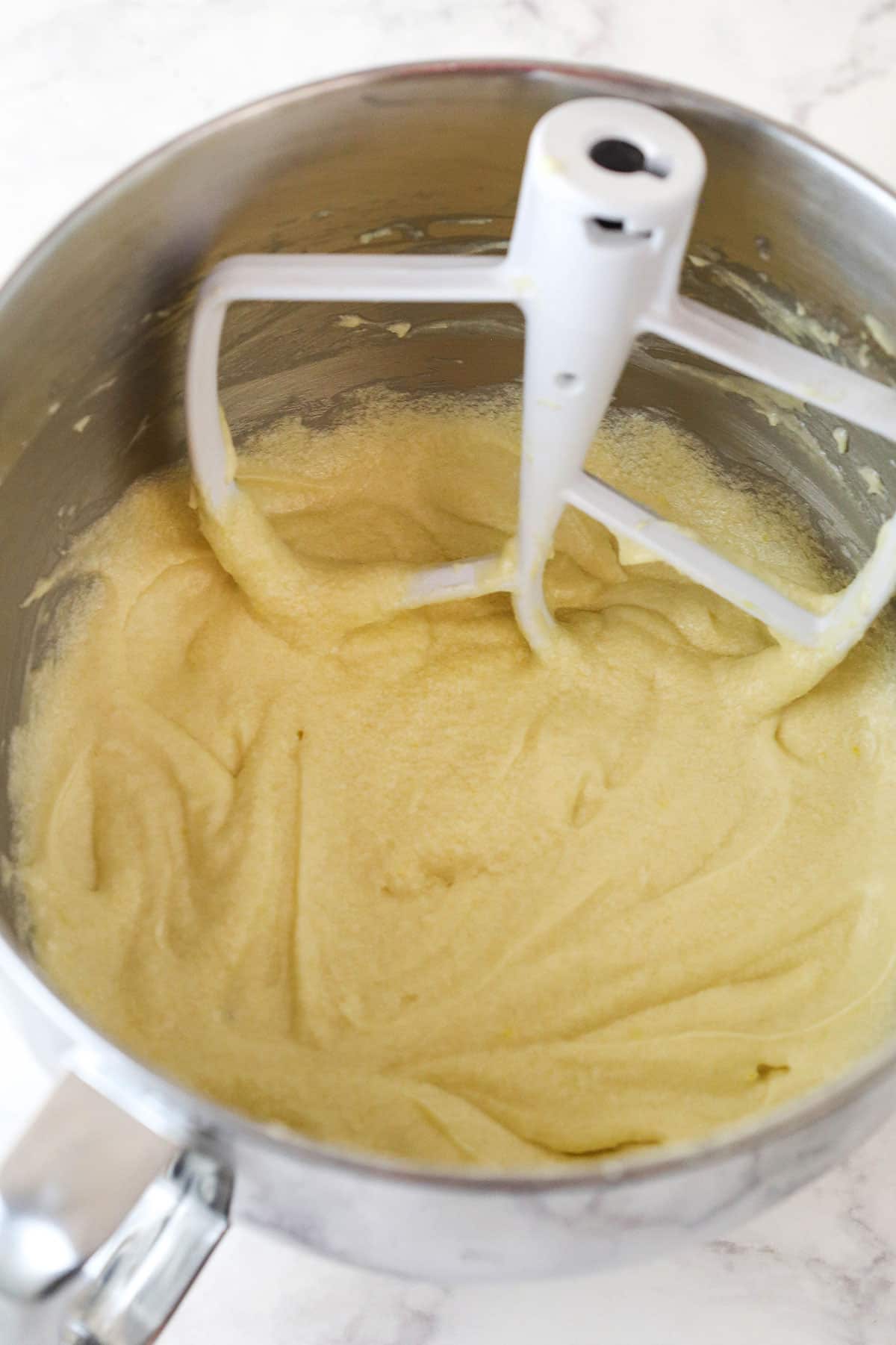 Overhead view of dry ingredients and milk combined to batter in a large mixing bowl