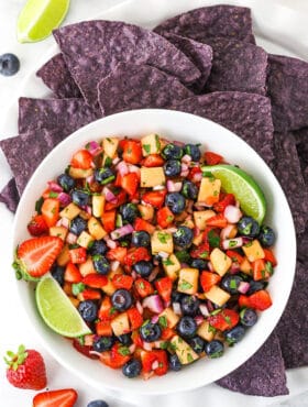 overhead image of berry fruit salsa in white bowl with blue tortilla chips