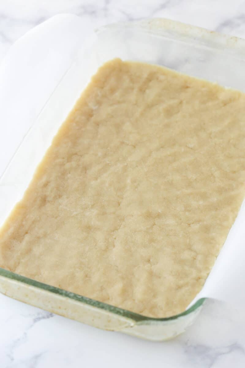 Easily the best homemade lemon bars ever! Perfectly sweet and tart, with a buttery cookie crust and creamy, crack-free lemon curd filling. unbaked crust pressed into the glass pan