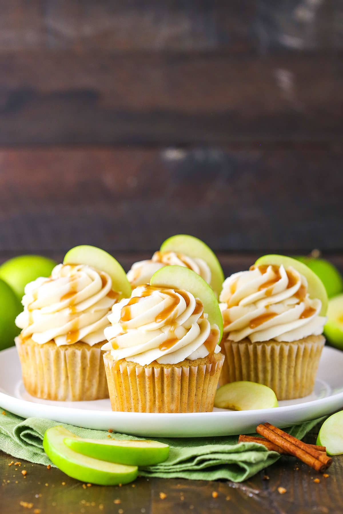 Caramel Apple Cupcakes topped with frosting swirls, a slice of apple and caramel sauce