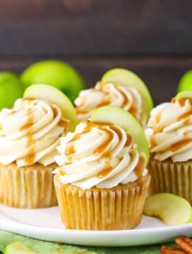 Caramel Apple Cupcakes topped with frosting swirls, a slice of apple and caramel sauce