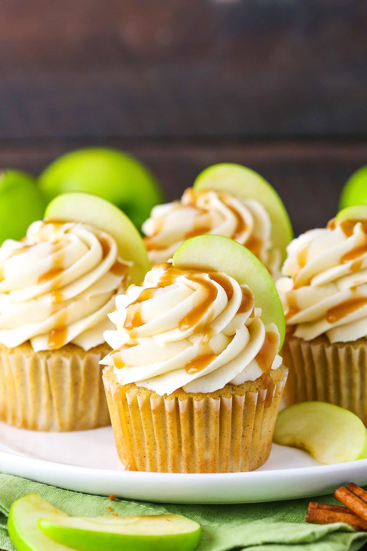 Caramel Apple Cupcakes topped with frosting swirls, a slice of apple and caramel sauce