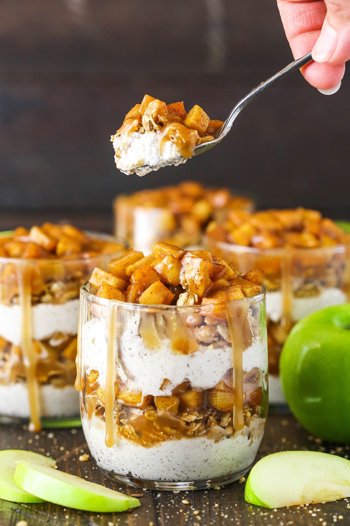 These Caramel Apple Trifles are the perfect apple treat for fall - no bake, super easy and full of cinnamon! Side image of a Caramel Apple Trifle with a spoon lifting a spoonful out