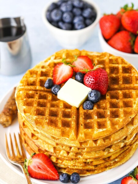 Overhead view of a stack of easy homemade waffles topped with butter and berries.