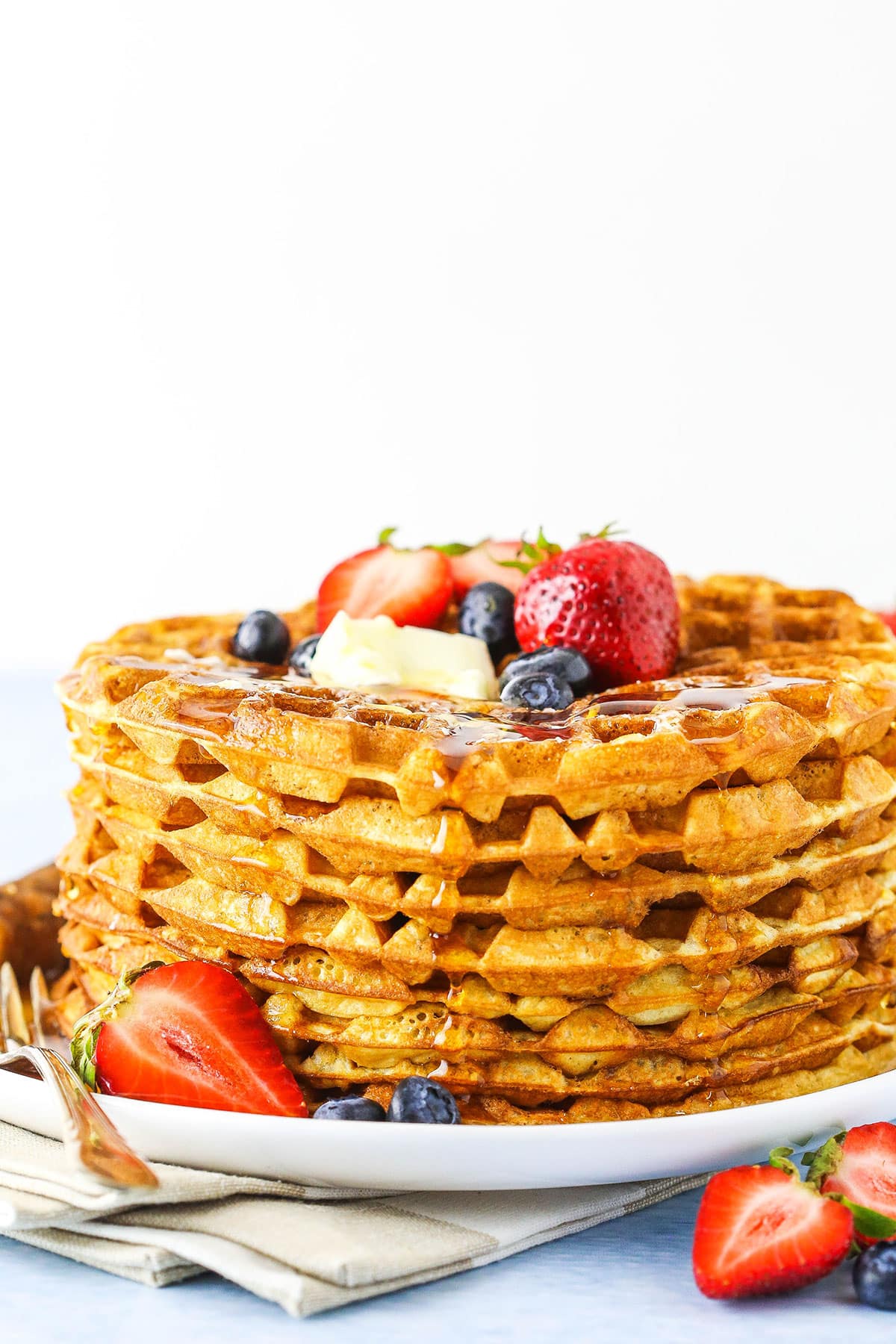 side close up of a stack of waffles with syrup