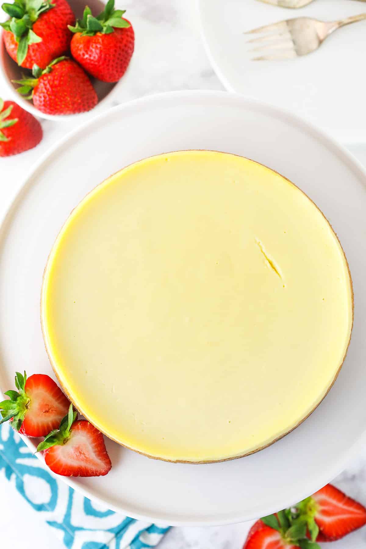 Overhead view of a full Instant Pot Cheesecake on a white cake stand