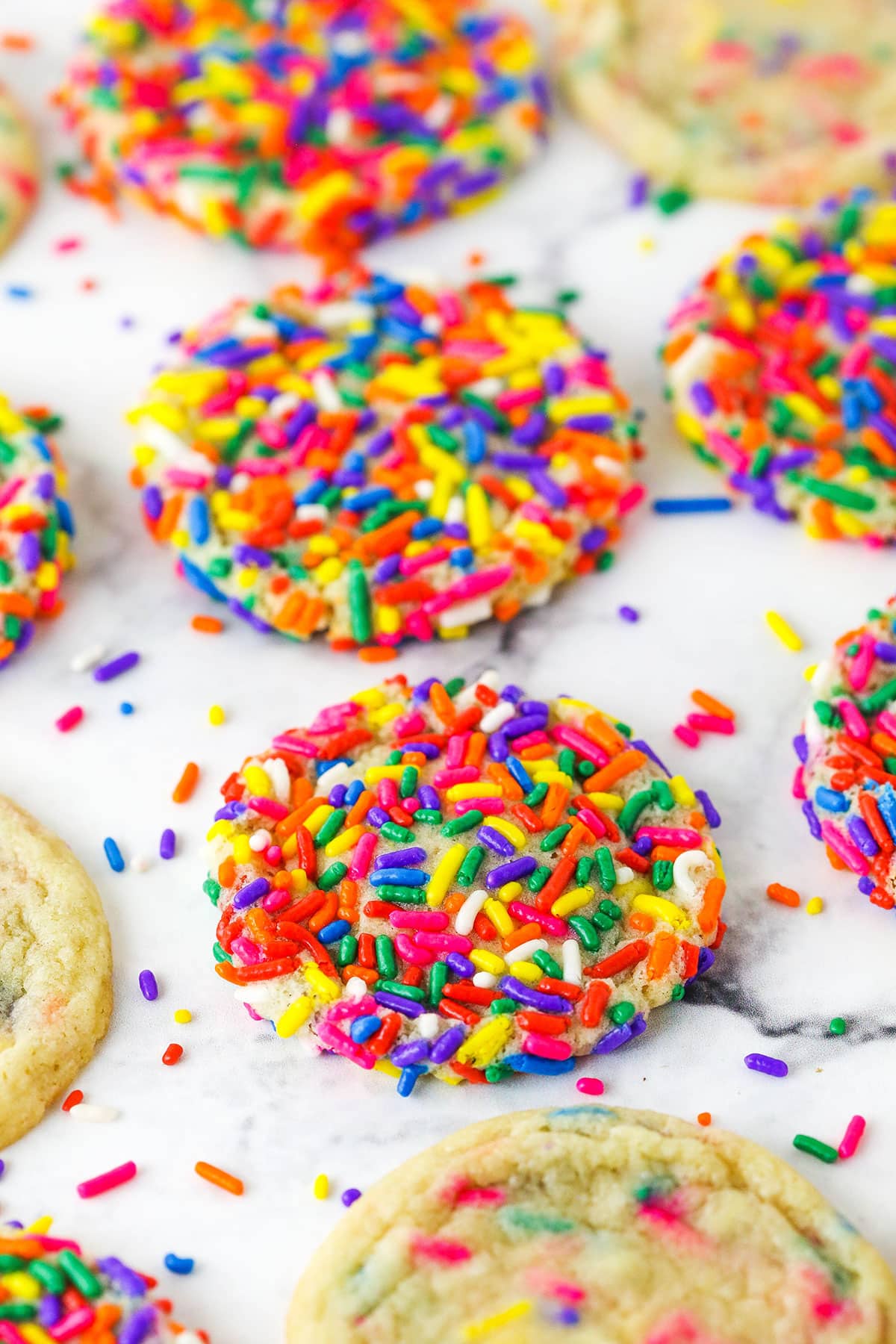 These beautiful Sprinkle Sugar Cookies are easy to make and perfect for summer snacking! Coat your cookies with a layer of your favorite sprinkles or fold the sprinkles right into the batter. Sprinkle Sugar Cookies with Rainbow Sprinkles