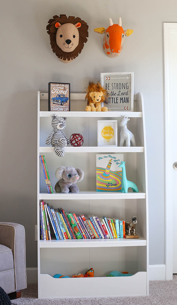 A White Shelf Filled with Baby Books and Animal-Themed Decorations