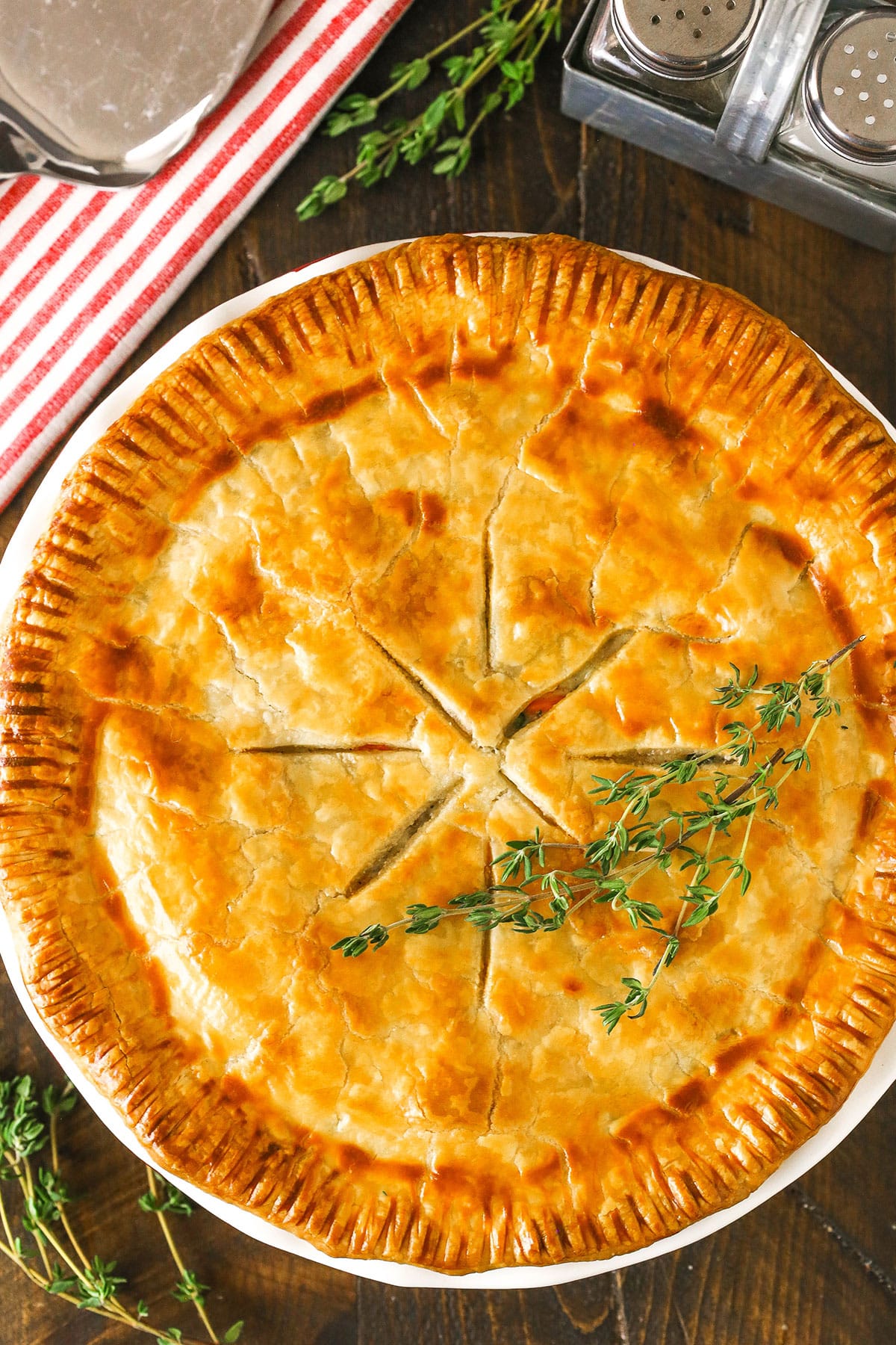 Overhead view of a full chicken pot pie in a white dish