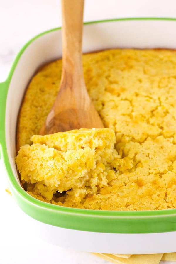 A Wooden Spoon Scooping out a Serving of Creamy Cornbread Casserole