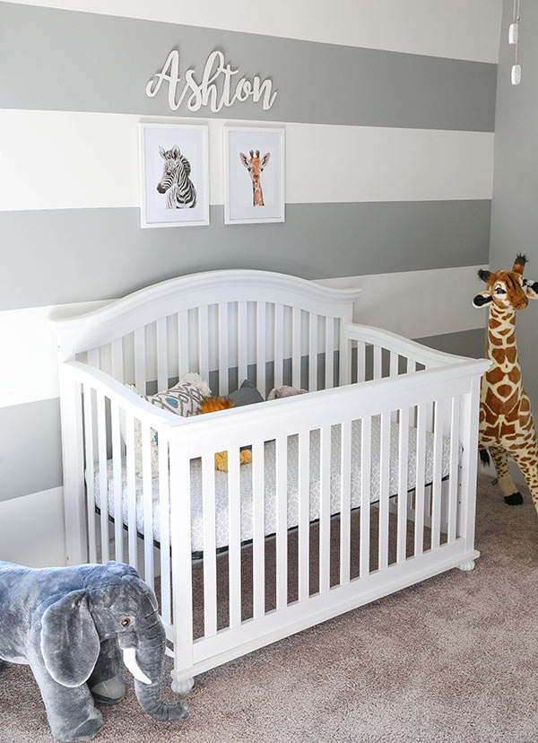 An Elephant Toy and a Giraffe Toy Perched on Either Side of Ashton's Crib