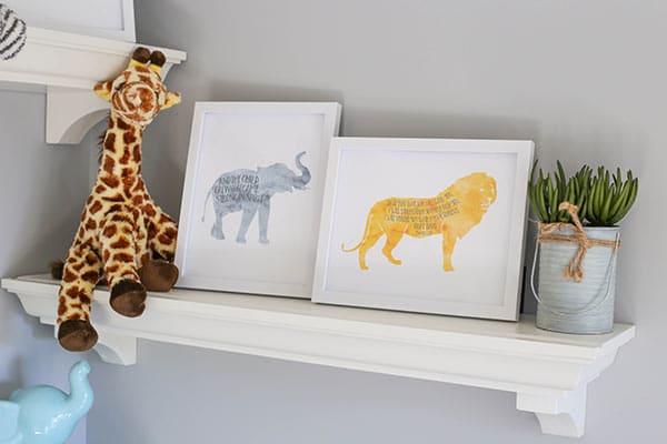 A Shelf with a Giraffe Toy, a Plant and Lion & Elephant Scripture Prints