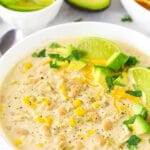 A Bowl of Instant Pot White Chicken Chili with Limes and Avocado