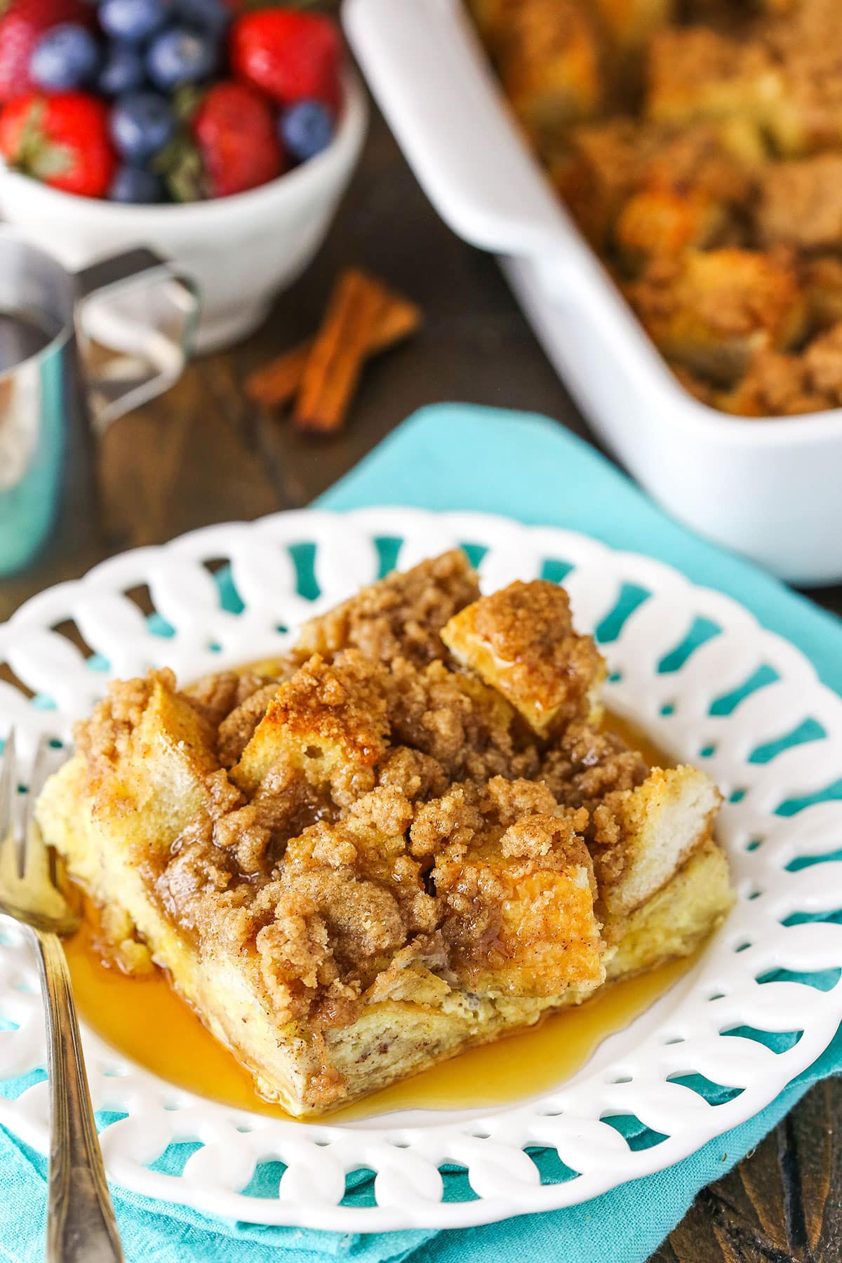 A slice of Overnight Cinnamon French Toast Casserole with syrup on a white plate