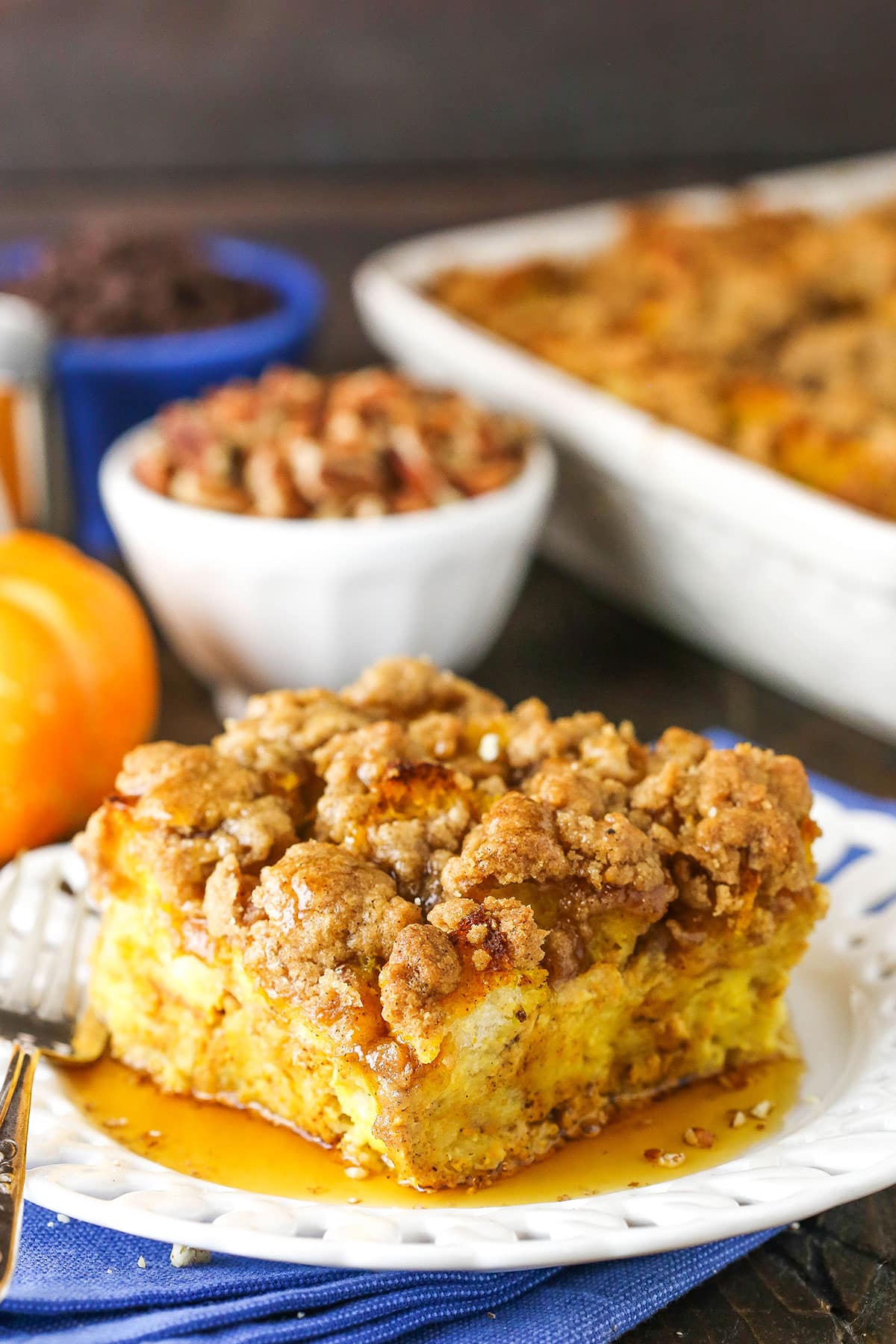 Side view of a square serving of Overnight Pumpkin Spice French Toast Casserole on a white plate with a fork