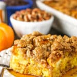 Side view of a square serving of Overnight Pumpkin Spice French Toast Casserole on a white plate with a fork