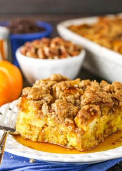 Side view of a square serving of Overnight Pumpkin Spice French Toast Casserole on a white plate with a fork