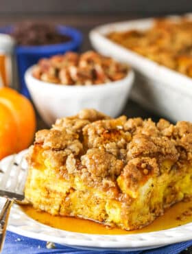 Side view of a square serving of Overnight Pumpkin Spice French Toast Casserole on a white plate with a fork