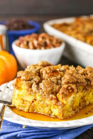 Side view of a square serving of Overnight Pumpkin Spice French Toast Casserole on a white plate with a fork