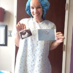 Lindsay in a Hospital Gown Holding Photo of Her Embryo