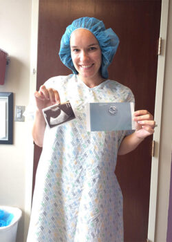 Lindsay in a Hospital Gown Holding Photo of Her Embryo