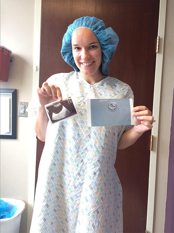 Lindsay in a Hospital Gown Holding Photo of Her Embryo