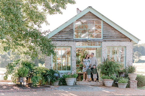 family standing in doorway of greenhouse