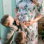 boys with their hands on Lindsay's belly