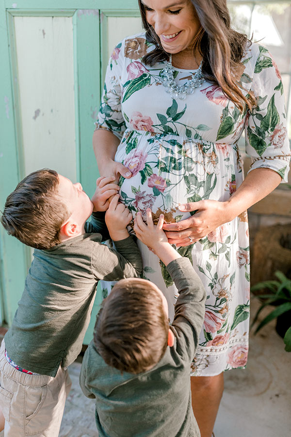 boys with their hands on Lindsay's belly