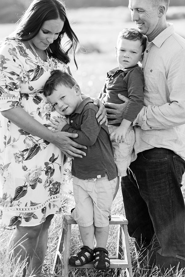 family in field, Brooks with head of baby belly