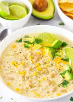 A Bowl of Instant Pot White Chicken Chili with Limes and Avocado