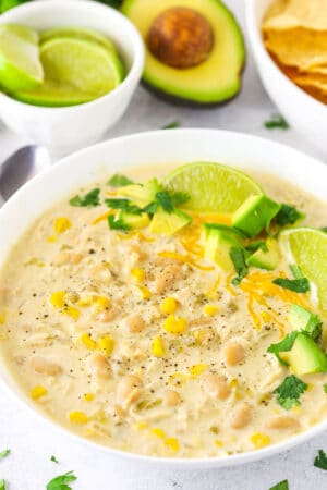 A Bowl of Instant Pot White Chicken Chili with Limes and Avocado
