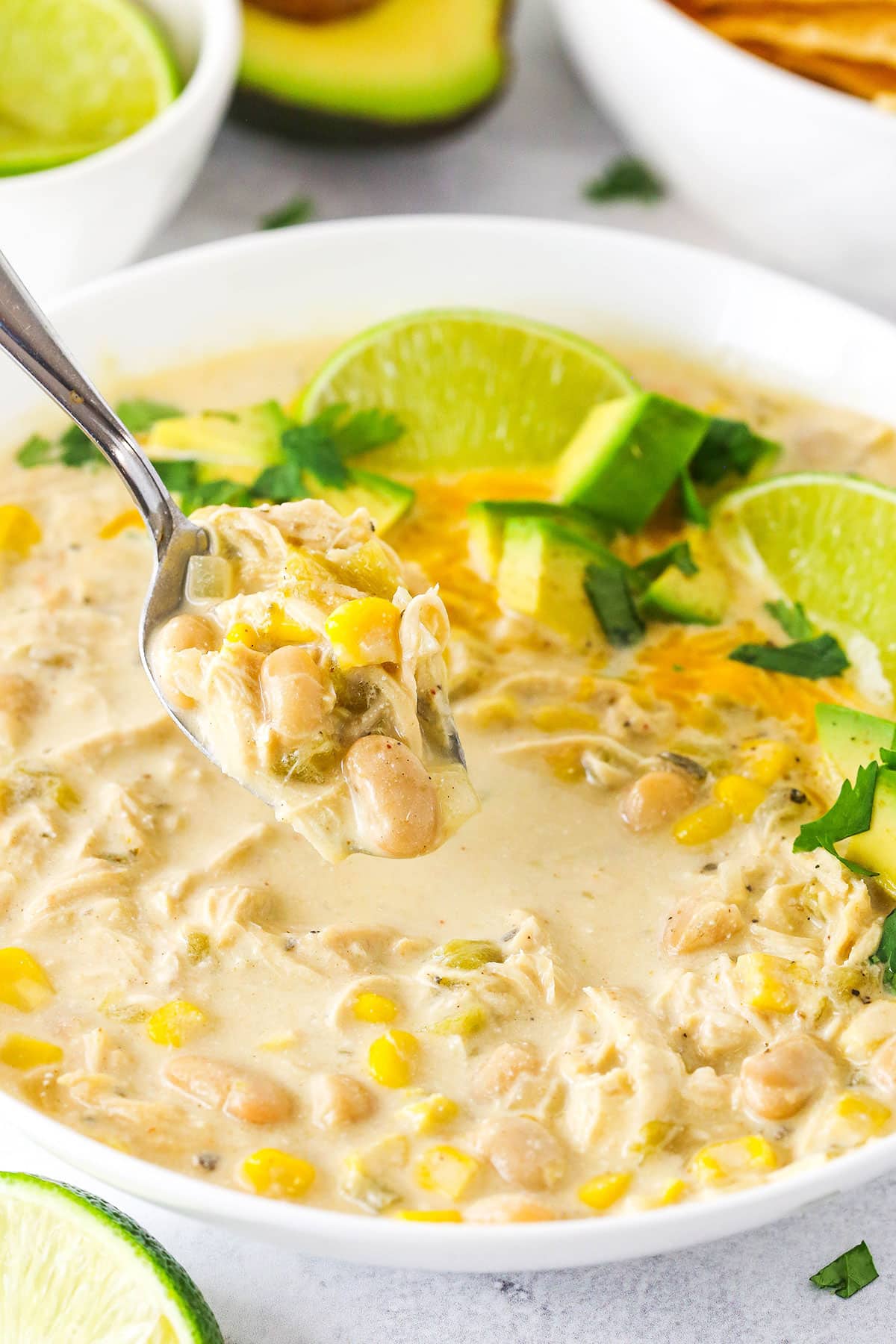 A Spoon Scooping out a Bite of White Chicken Chili From a Bowl