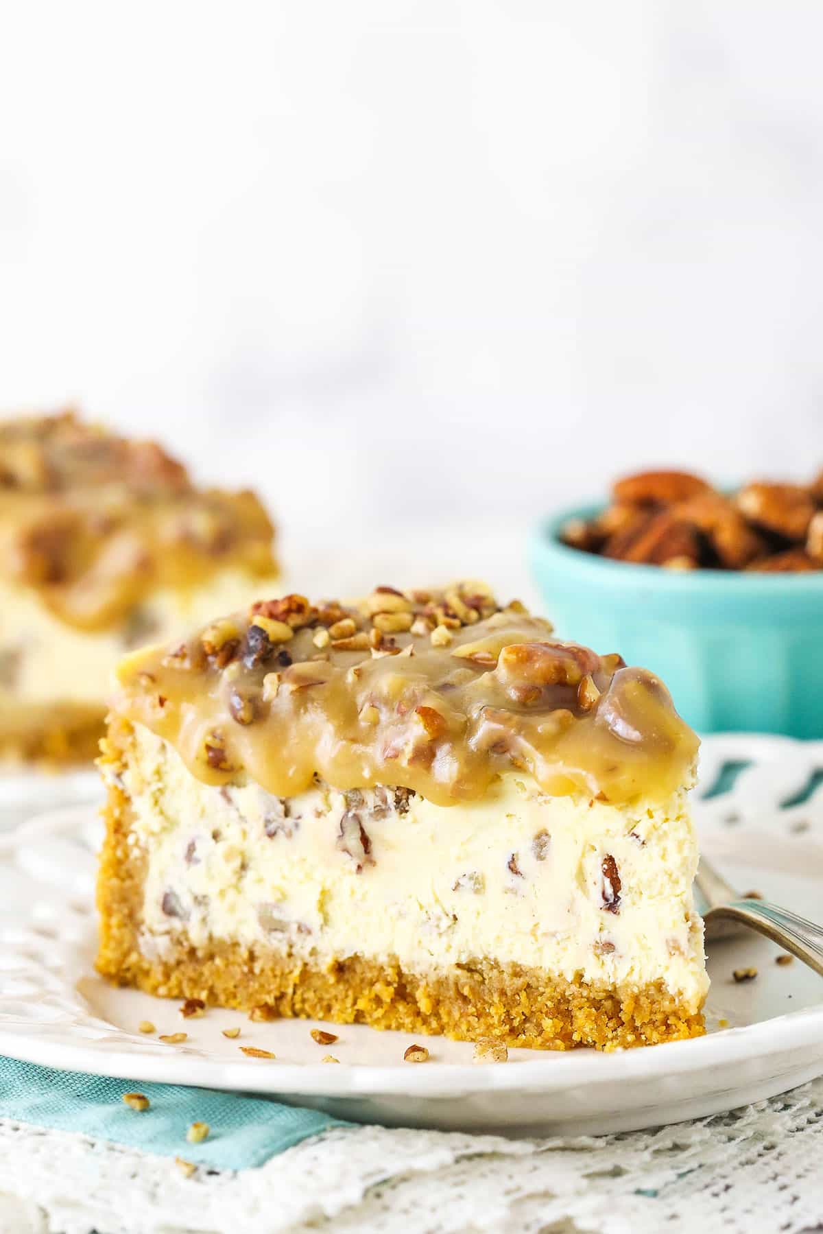 slice of pecan praline cheesecake with another slice in background