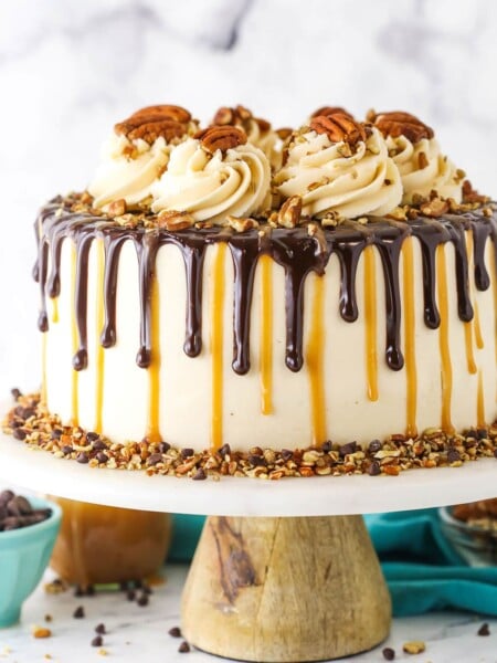 Side view of a full Turtle Chocolate Layer Cake on a white cake stand