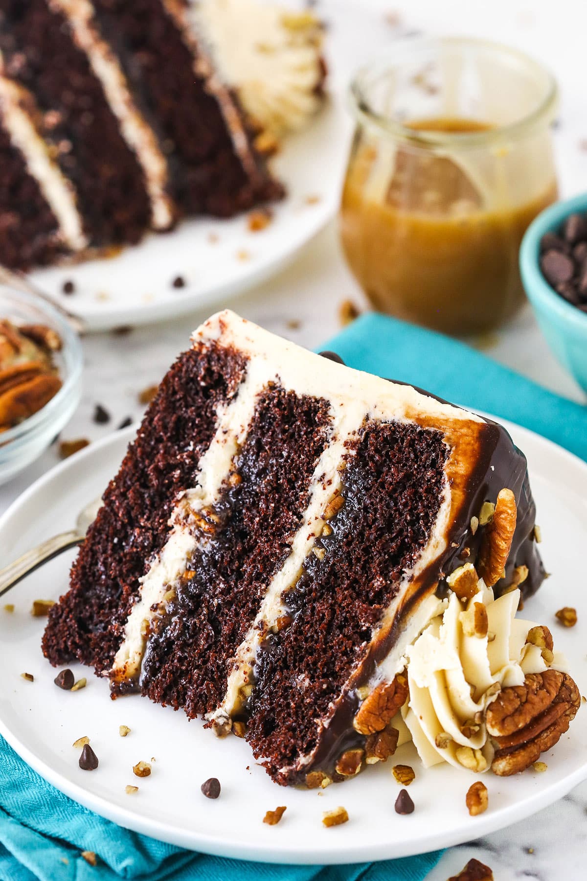 A slice of Turtle Chocolate Layer Cake on it's side on a white plate