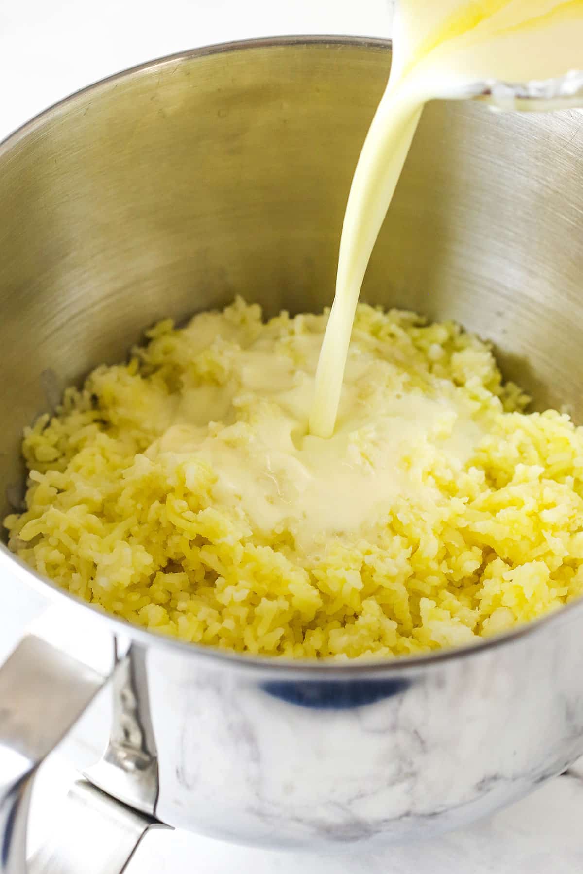 Step 5 pour riced potatoes into a mixer bowl and add hot cream and butter