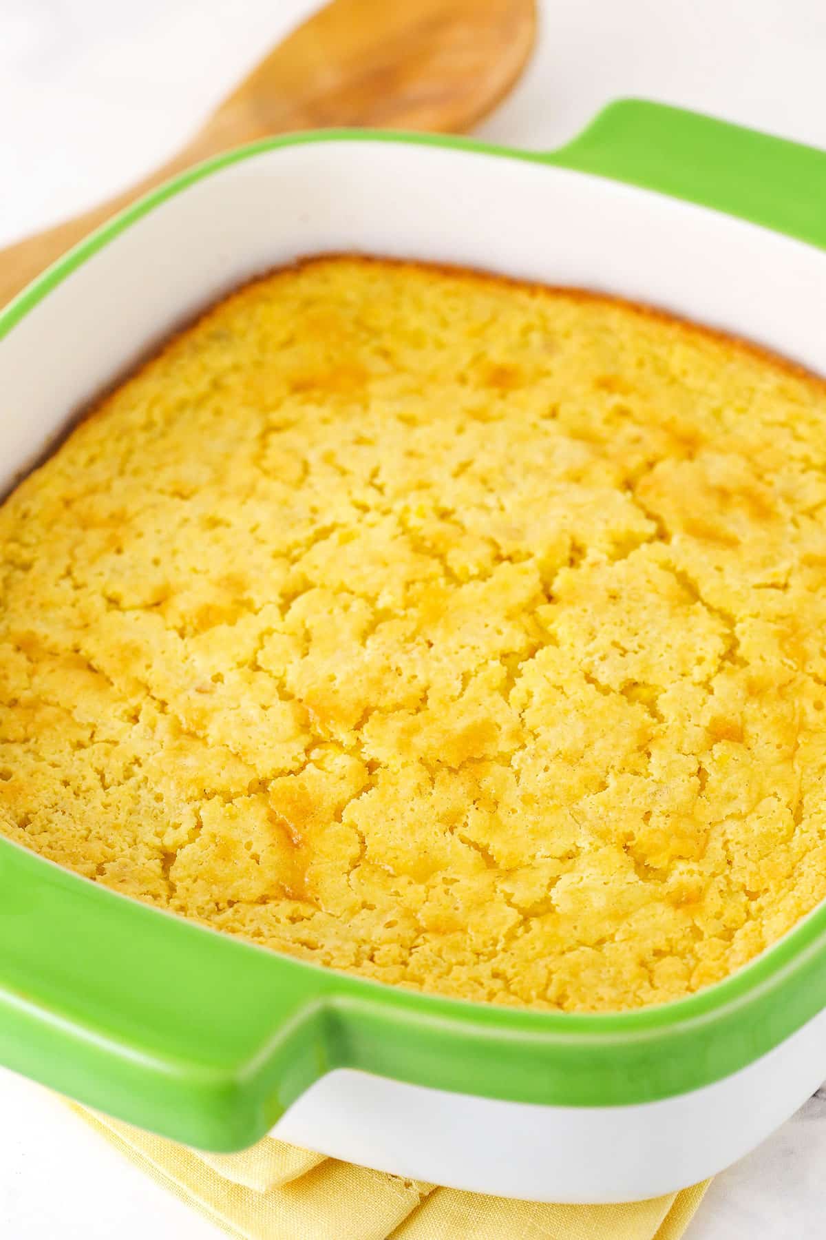 A Fresh Cornbread Casserole in a Green and White Baking Pan