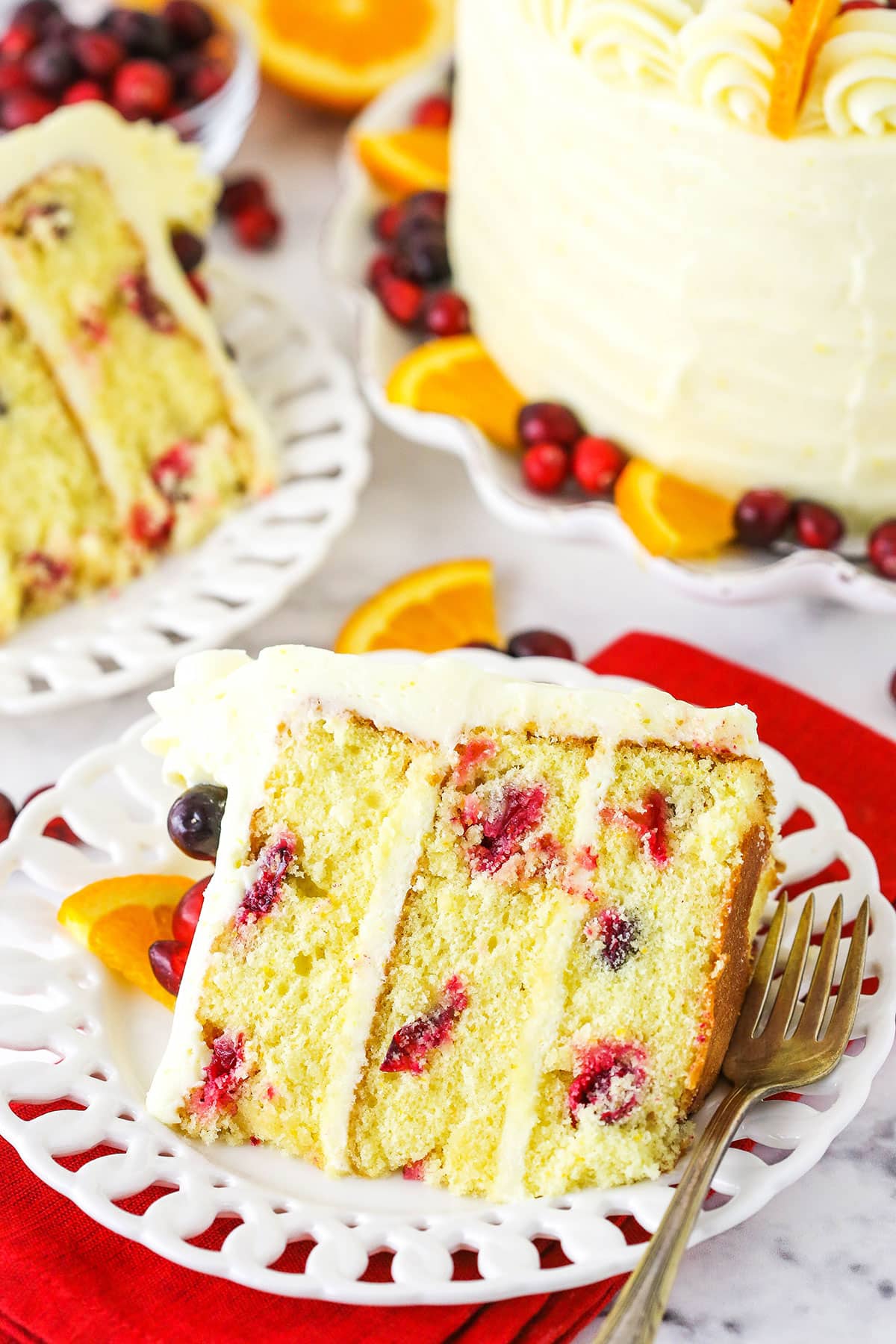 Overhead view of a slice of Cranberry Orange Layer Cake on it's side on a white plate.