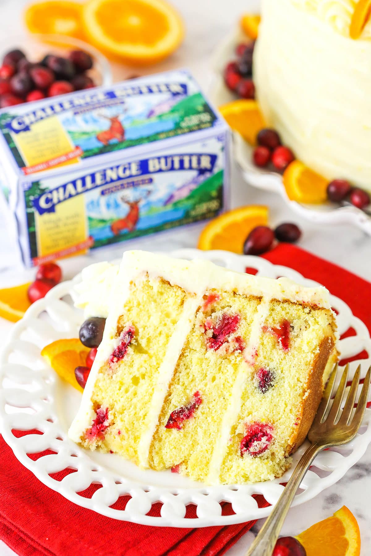 Overhead view of a slice of Cranberry Orange Layer Cake on it's side with Challenge Butter in the background.