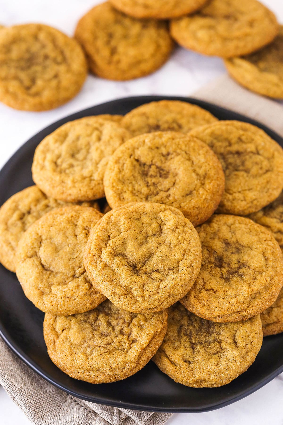 A Plate Full of Molasses Cookies With Five Stray Cookies on the Counter
