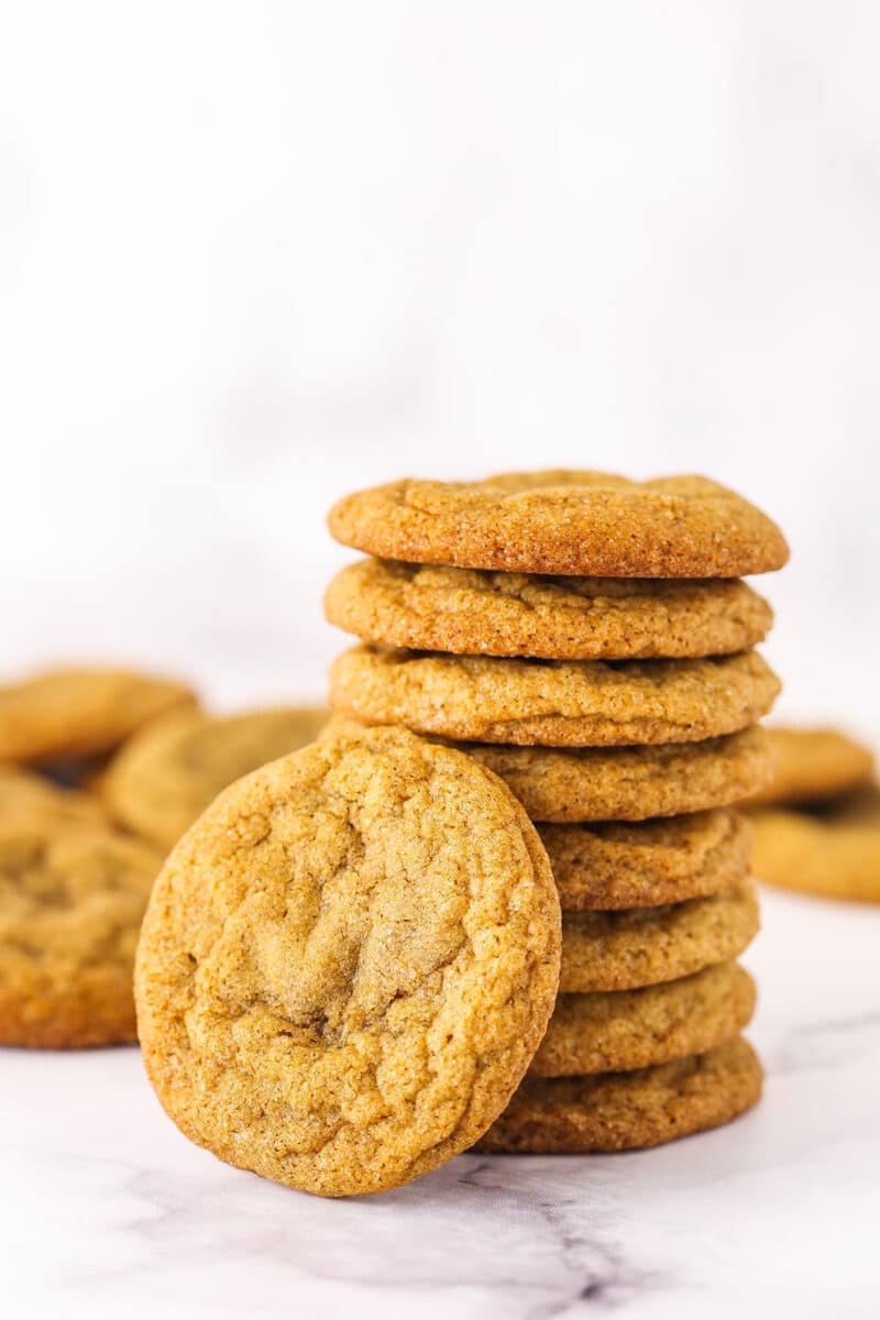 A stack of eight molasses cookies plus another one leaning against the stack.