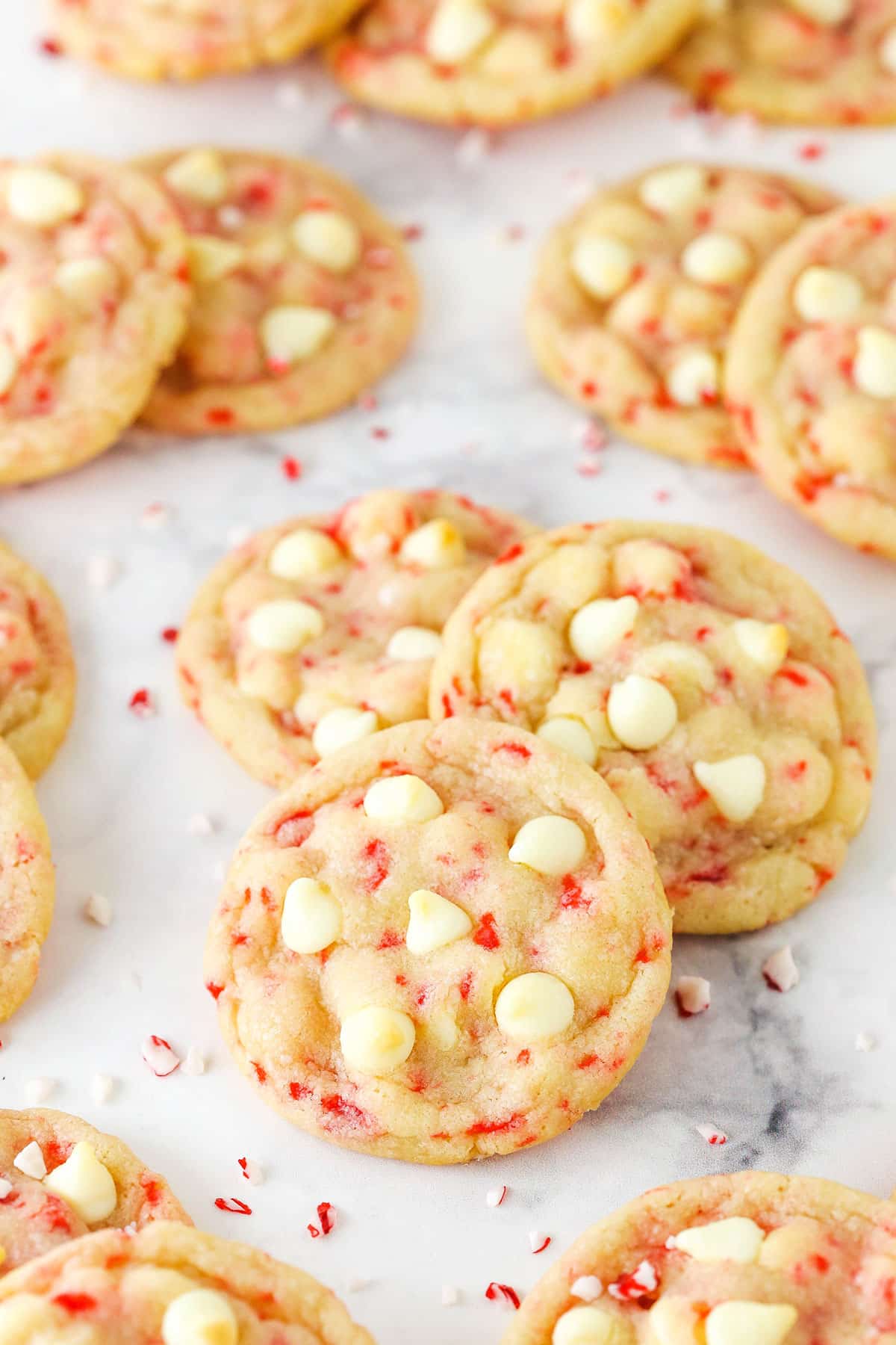 Peppermint sugar cookies grouped together on the counter with crushed peppermint pieces.