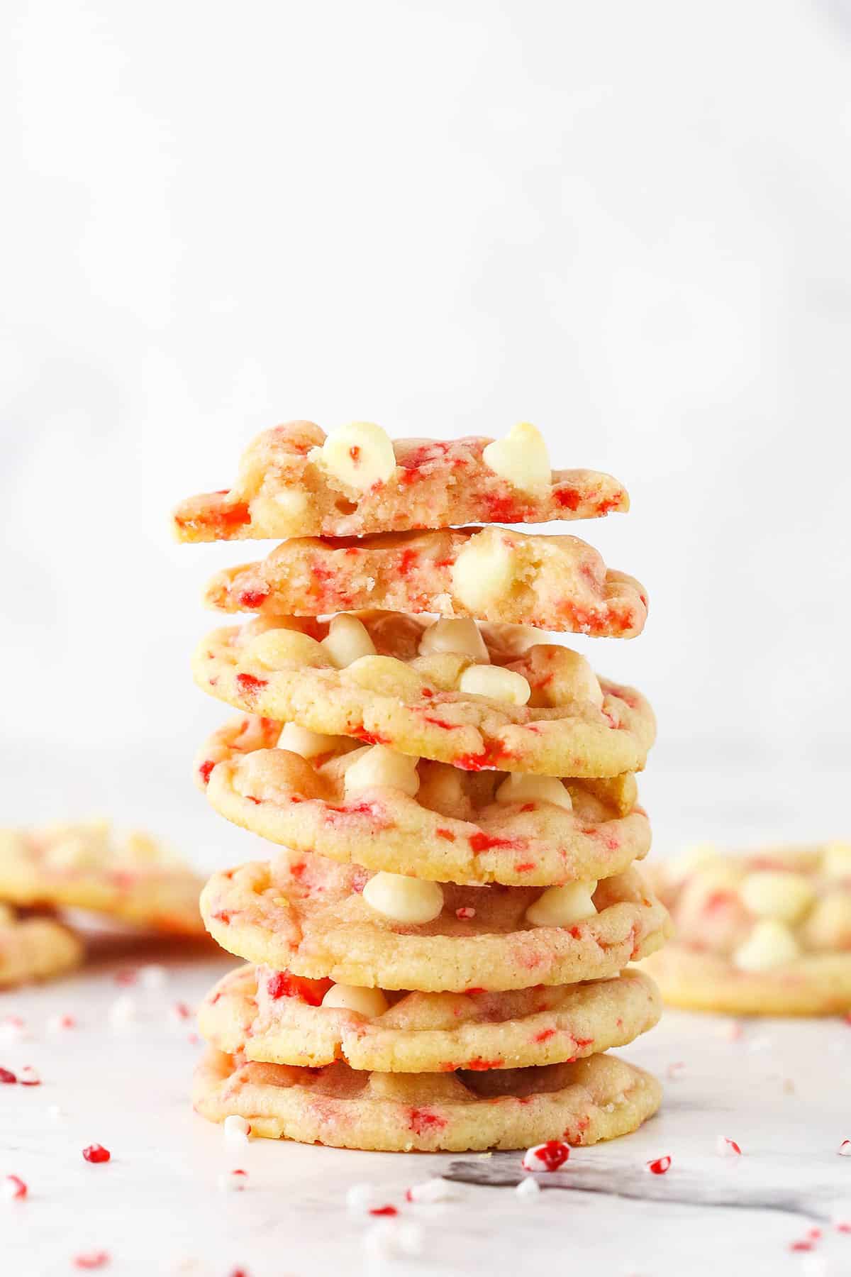 White chocolate peppermint sugar cookies stacked on a countertop.