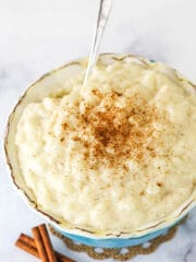 Warm Rice Pudding in a Teal Bowl with a Silver Spoon
