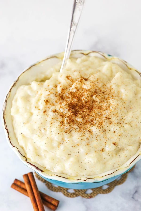 Warm Rice Pudding in a Teal Bowl with a Silver Spoon