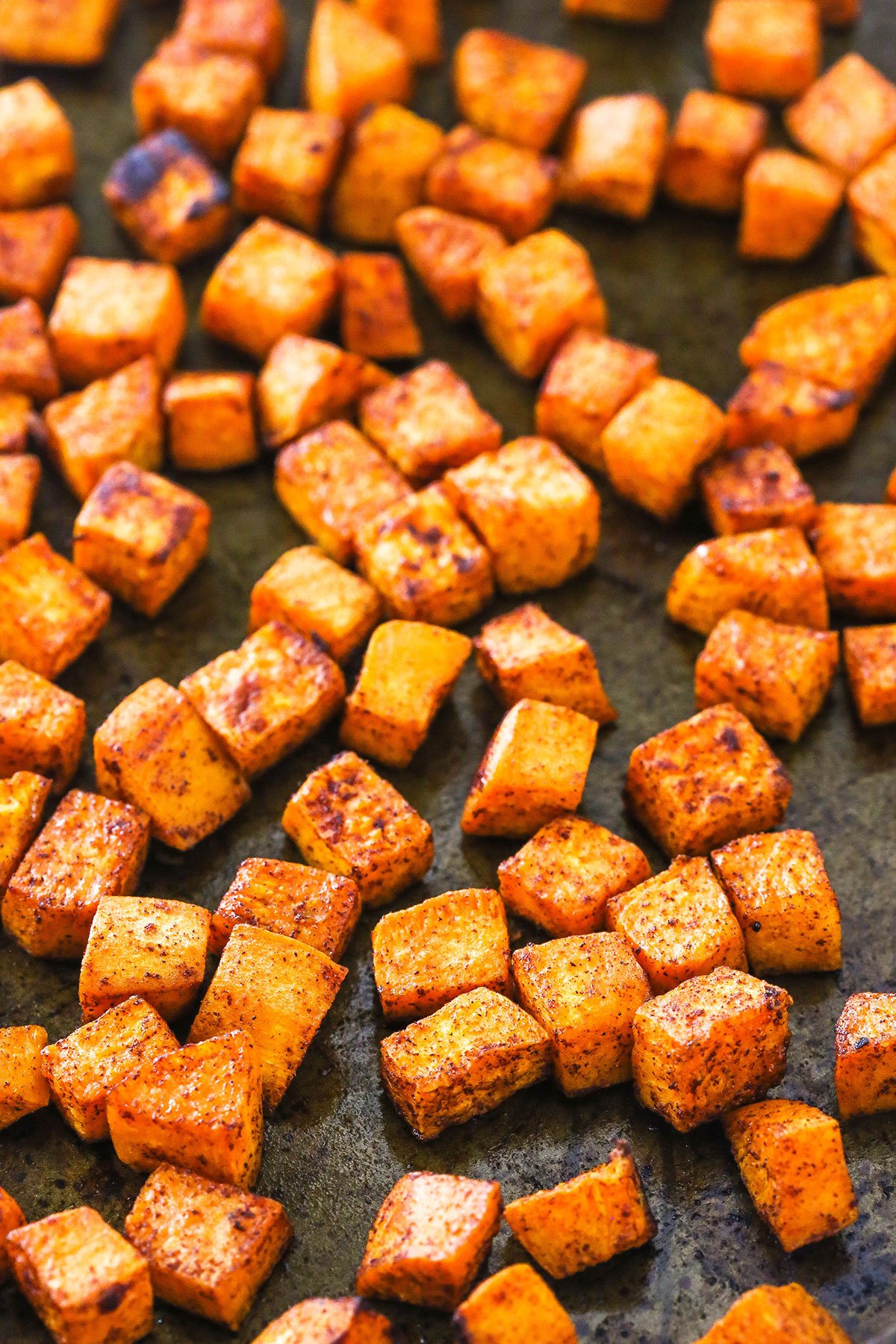 Roasted sweet potatoes arranged on a baking pan.